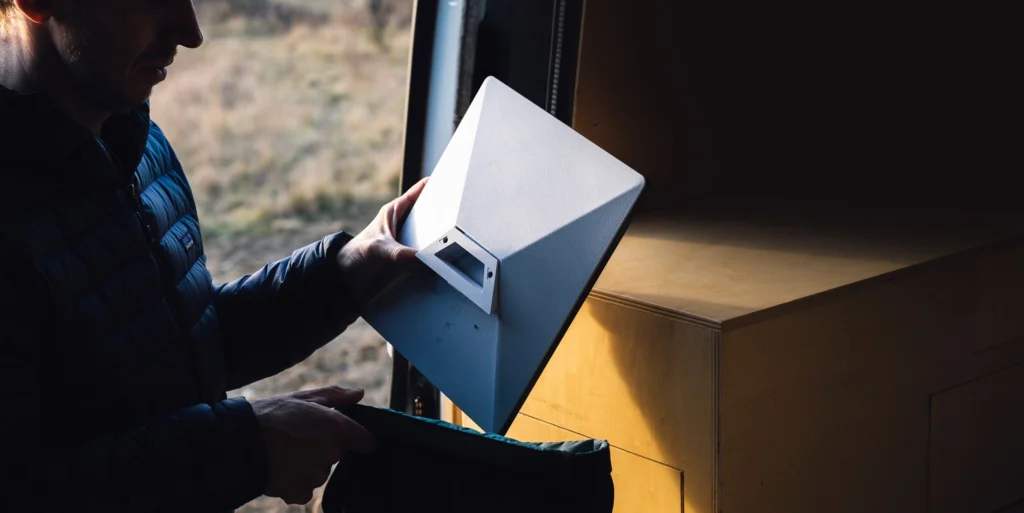 Homem segurando antena portátil Starlink Mini para conexão de internet via satélite em área remota rotina.